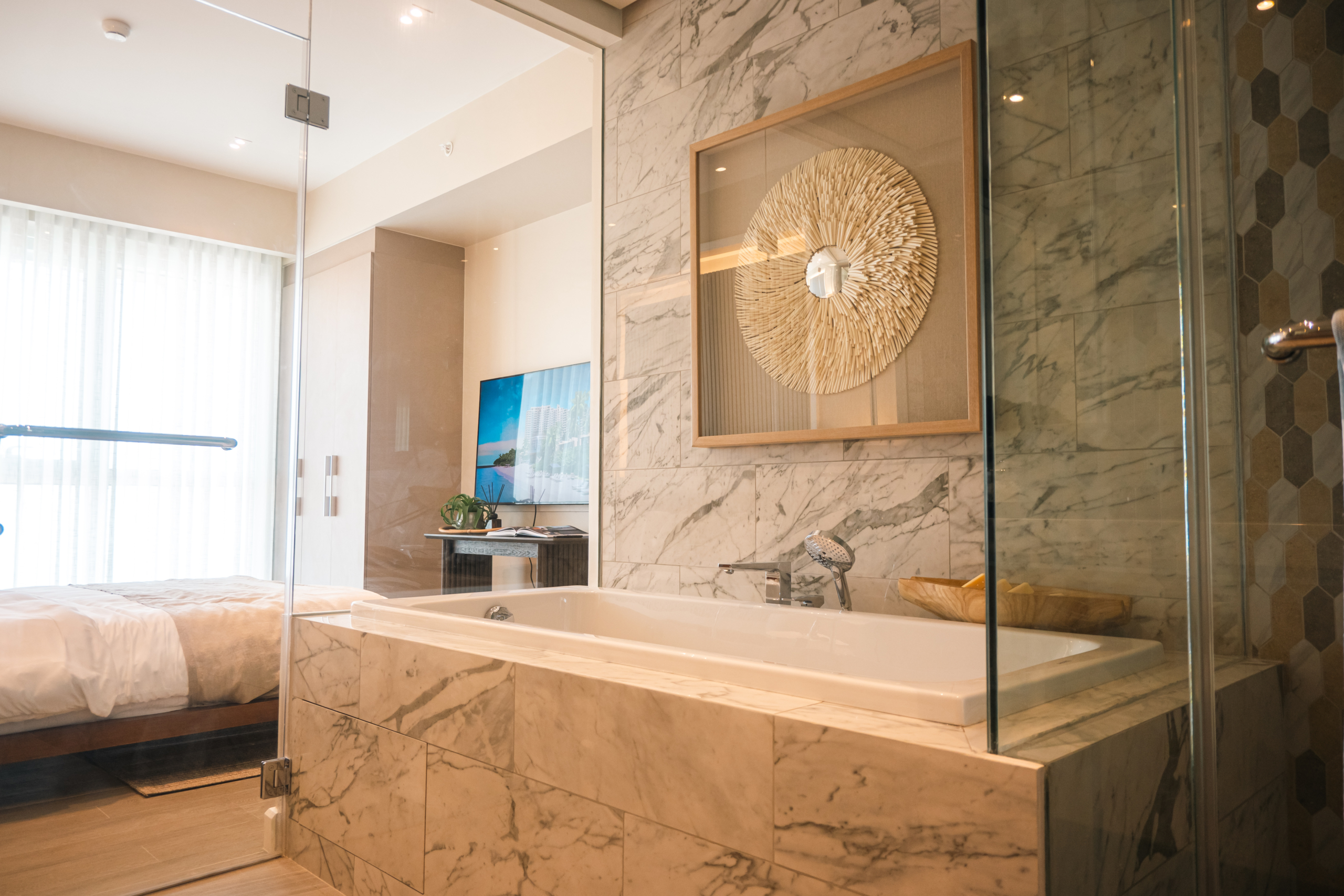 The Primary Bedroom of Aruga Mactan's 2 Bedroom unit features a relaxing ensuite bathroom with bathtub.